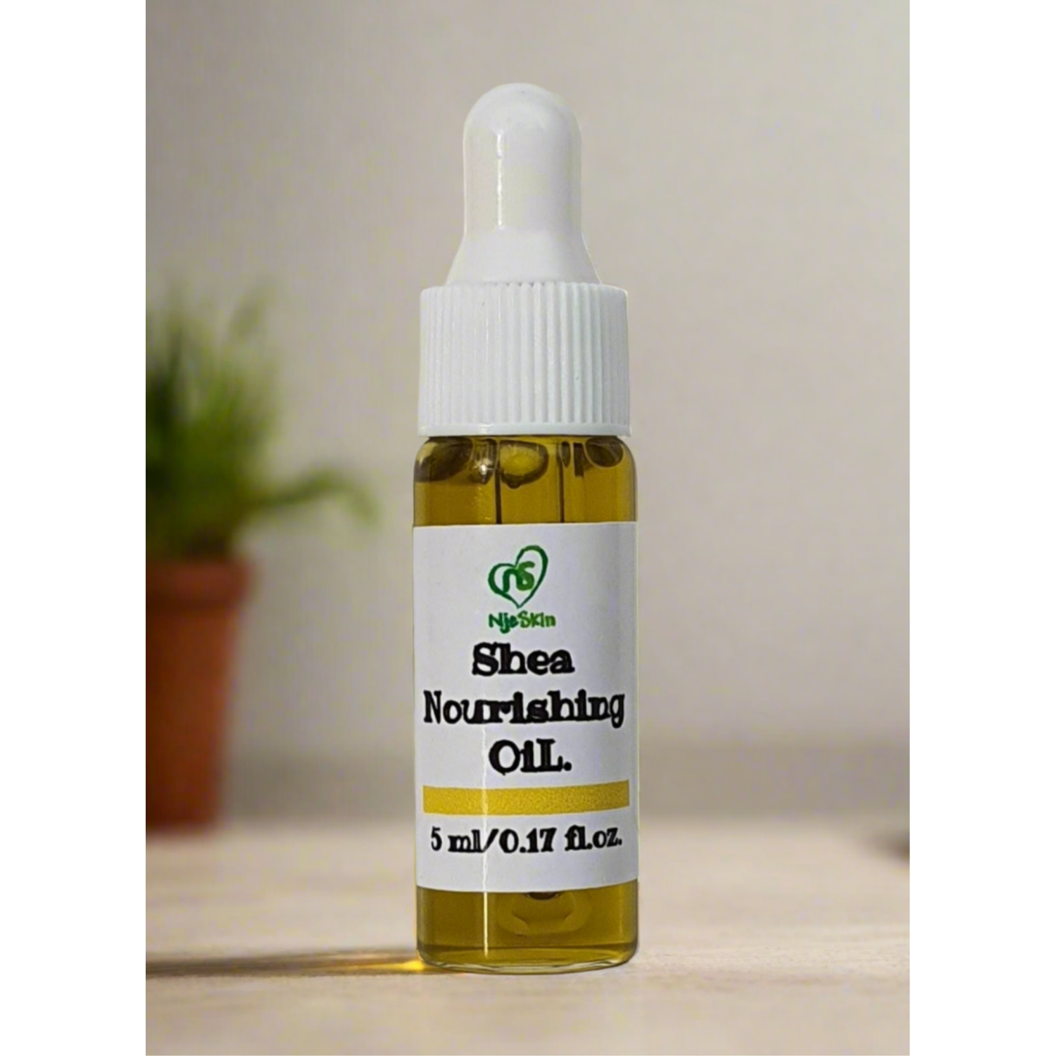 A bottle of Shea Nourishing Oil with a dropper, labeled with the brand Njeskin and the product name clearly visible.